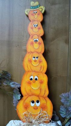 a group of oranges sitting on top of a pile of hay with eyes drawn on them