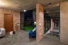 a living room filled with furniture next to a brick wall and glass door leading to a balcony