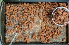 a pan filled with nuts next to a spoon