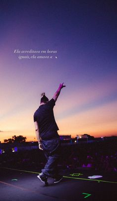 a man on a stage with his arms up in the air and an inspirational quote above him