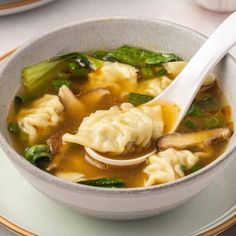 a white bowl filled with dumplings and vegetables