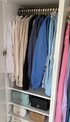 an organized closet with clothes and handbags on the shelves, including sweaters and purses