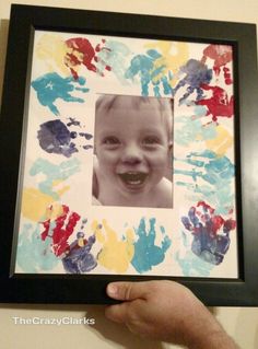 a child's handprinted picture in a frame