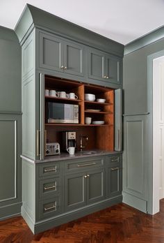 a kitchen with gray cabinets and wooden floors