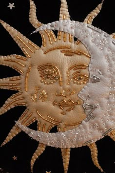 an embroidered sun and moon with stars in the background