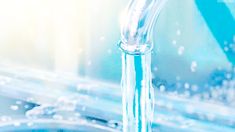 a faucet that is running out of water in a sink with blue and white background