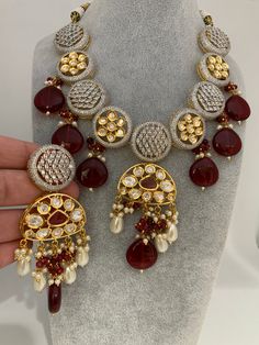 Kundan AD Red Beads Short Necklace with Matching EarringsColor : GoldenSize : Necklace Length : Approx 16 Inches; Earring Length : 3.75 InchesStones : Kundan AD Red Stone Red Beads Pearls