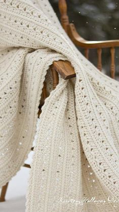 a white crochet shawl draped over a wooden chair with the text, free crochet pattern