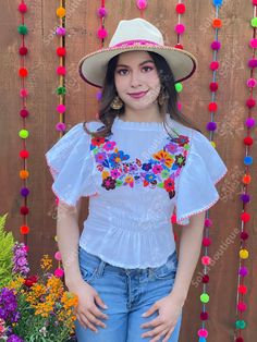 This beautiful Flounce Sleeve Top is the perfect Top for a fun day out or special event. The adorable fluttery sleeves and colorful hand embroidered flowers make it flirty and fun. It's made out of fine Mexican cotton, has an elastic waist and has colorful flowers embroidered completely by hand. This blouse is made with love by Mexican Artisans in Chiapas, Mexico. Please note: This blouse comes in one size which fits sizes Small and Medium. Purchase the Mexican hats here: https://www.etsy.com/es Folk Style Fitted Blouse For Fiesta, Fitted White Festival Top, Fitted White Tops For Festival, Summer Festive Blouse With Floral Embroidery, Festive Floral Embroidered Summer Blouse, Fitted Multicolor Embroidered Blouse For Beach, Festive Floral Embroidered Blouse For Summer, Fitted Blouse With Multicolor Embroidery For Beach, Fitted Short Sleeve Blouse For Fiesta