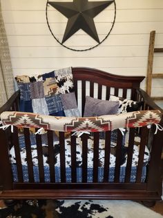 a baby crib in front of a wall with a star hanging on the wall