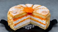 an orange and white cake on a black plate