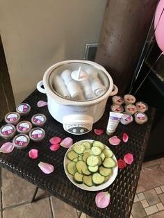 a table topped with lots of cupcakes and an ice bucket filled with frosting