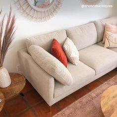 a living room with a couch, coffee table and mirror on the wall above it