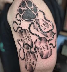 a man with a dog's paw and two tags on his arm that have chains attached to them