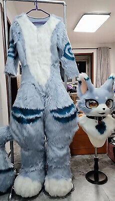 a blue and white cat costume sitting on top of a chair next to a stuffed animal