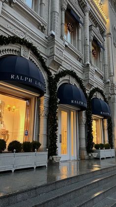 the facade of a building with christmas decorations on it's windows and steps leading up to them