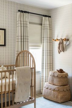 a baby's room with a crib, rocking chair and wallpaper