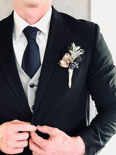 a man wearing a suit and tie with a boutonniere on his lapel