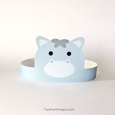 a blue animal shaped box with a bow on it's head, sitting in front of a white background