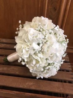 a bouquet of white flowers sitting on top of a wooden crate