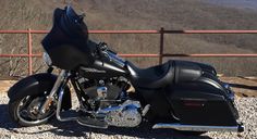 a black motorcycle parked on top of a hill