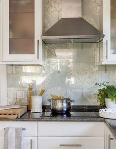 a stove top oven sitting inside of a kitchen next to white cabinets and counter tops