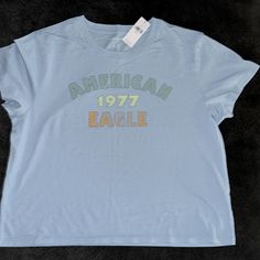 Nwt American Eagle Graphic Tee , Size Large. It’s A Baby Blue Color Basic Blue Tops With Text Print, Retro Blue Tops With Letter Print, Retro Blue Top With Letter Print, Basic Blue Tops With Graphic Print, Light Blue Basic Tops With Graphic Print, Light Blue Basic Top With Graphic Print, Eagle Graphic Tee, American Eagle Outfits, Eagle Graphic