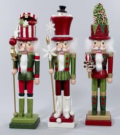 three wooden nutcrackers are standing next to each other with christmas decorations on them