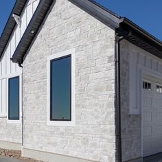 a white house with two garage doors and windows