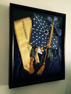 an image of graduation caps and diplomas hanging on the wall in a black frame