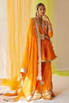 Orange zardozi sequins work angrakha kurta. Paired with embroidered gharara and mul silk dupatta.
Components:3
Pattern:Embroidered
Type of Work:Sequins, Zardozi work, Mukaish work
Neckline:V neck
Sleeve Length:Three quarter
Fabric:Cotton, Mul silk
Color:Orange
Other Details:
Embroidered dupatta
Side tie up detail
Occasion:Wedding,Sangeet - Aza Fashions Orange Indian Outfit, Priyanka Singh, Zardozi Work, Lehenga Designs, Silk Dupatta, Indian Outfit, Indian Fashion Dresses, Designer Gowns, Kids Sleepwear