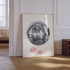 a mirror ball is hanging on the wall next to a wooden table with lipstick prints