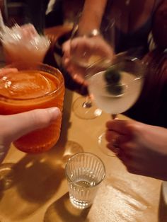 several people are sitting at a table with drinks