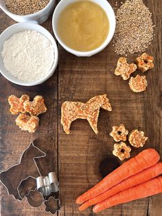 carrots, dog treats and other ingredients on a wooden table with cookie cutters