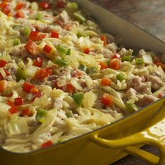 a yellow casserole dish filled with pasta and vegetables