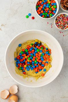 a bowl filled with cereal and sprinkles next to two bowls full of eggs