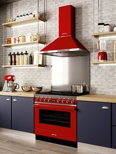 a red stove top oven sitting inside of a kitchen next to wooden counters and shelves