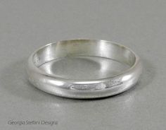 a close up of a wedding ring on a gray surface with the word love written in it