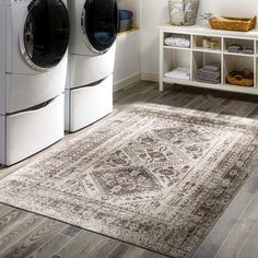 a washer and dryer sitting next to each other in a room with wooden floors