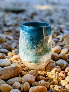 a blue and white vase sitting on top of rocks