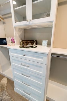 a white cabinet with drawers and other items on it in a room that has carpeted flooring