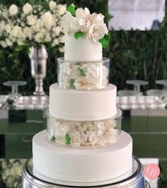 a three tiered cake with white flowers on top