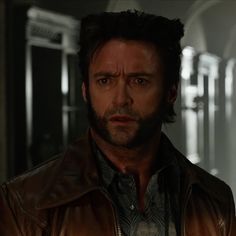 a man in a leather jacket looking at the camera with an intense look on his face