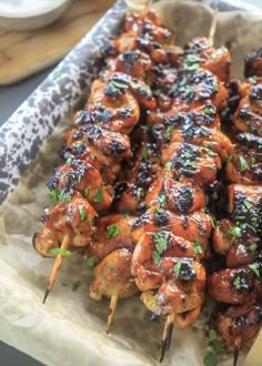 chicken skewers with sauce and parsley on top