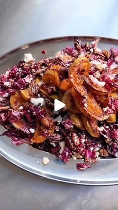 a white plate topped with red cabbage and nuts