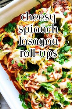 a white plate topped with lasagna roll ups covered in cheese and spinach