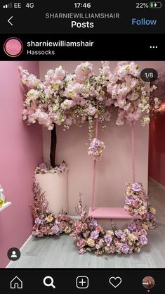 a pink room with flowers on the wall and a swing in the middle that is hanging from it's ceiling