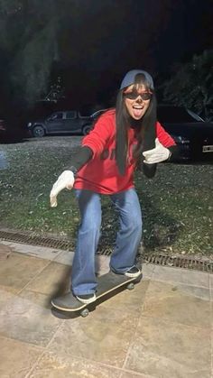 a woman riding a skateboard down a sidewalk