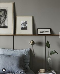 a bedroom with gray walls and pictures on the wall