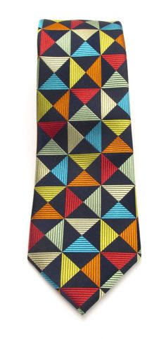 A detailed woven multicoloured silk tie with it's gold, red, teal, orange and sage green geometric design, creates a very distinctive pattern. Our Van Buck Red Label Silk Tie Collection is woven from heavier silk yarn to give a nice quality feel, vibrant colours as well as the perfect knot. This range is perfect for weddings, a day at the office or a day at the races. The quality of fabric we use for our ties is outstanding, making them a distinctive quality piece of gentleman's neckwear. 100% Silk Width: 7.5cm Length: 145cm Luxury Multicolor Standard Tie, Orange And Sage Green, Tie Collection, Teal Orange, Red Label, Silk Yarn, Race Day, Silk Ties, Geometric Design